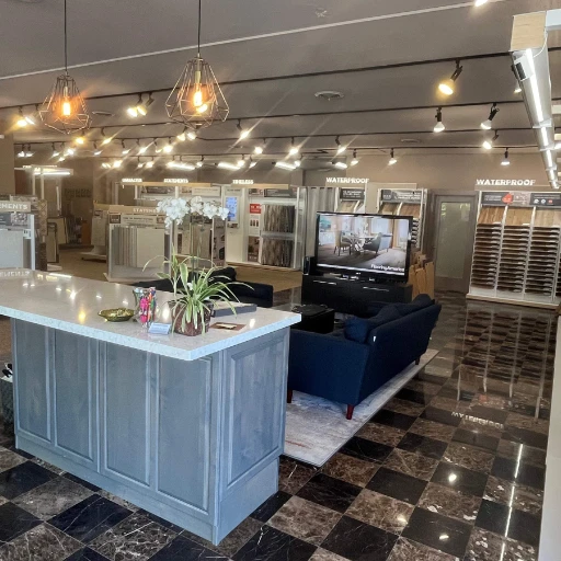 Entrance of Flooring America Seattle showroom featuring a modern counter, cozy seating, and well-lit displays of wood, tile, and waterproof flooring options in a welcoming, stylish setting.