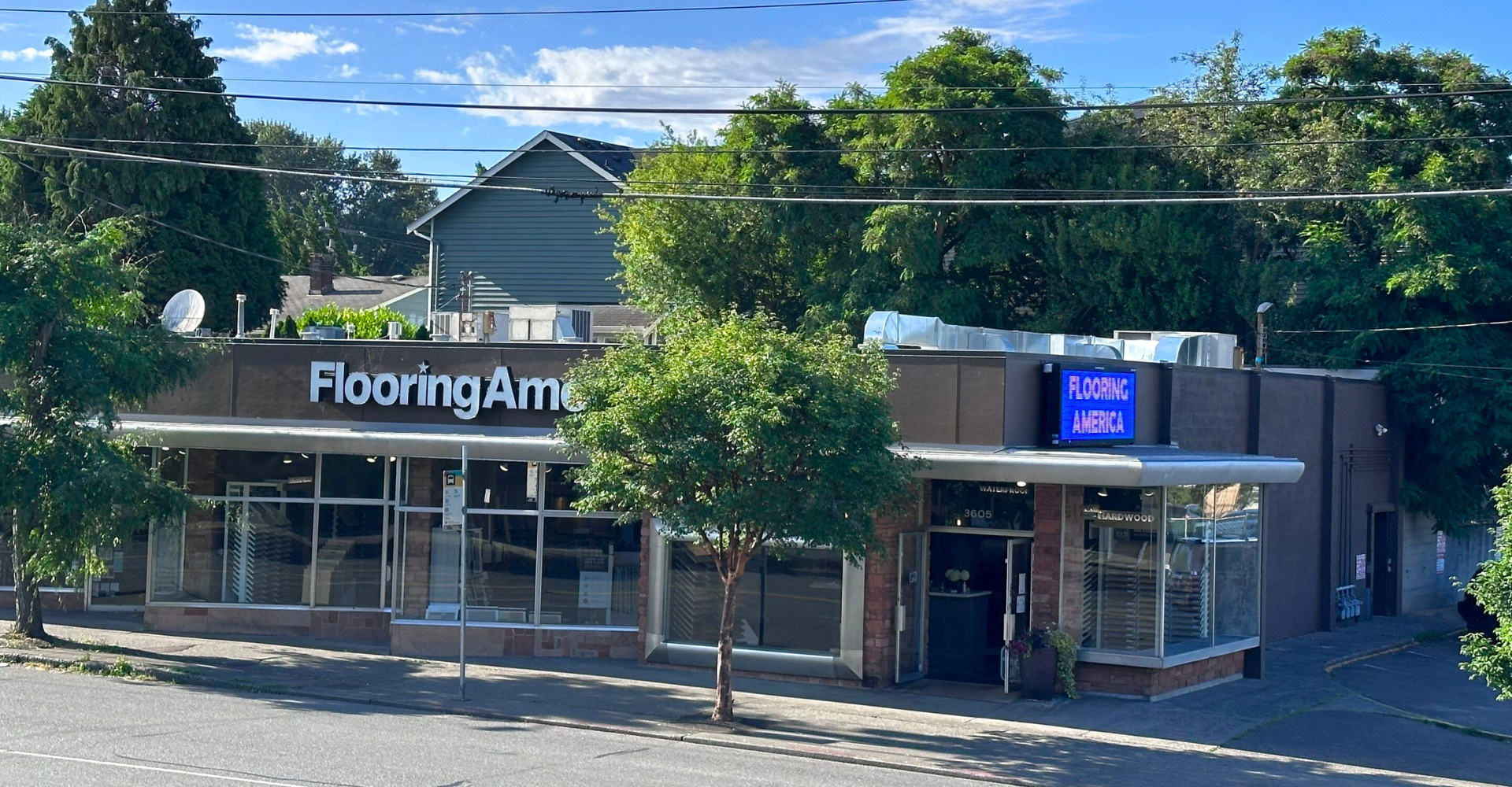 Flooring America, 3605 NE 45th St, Seattle, WA, with modern facade, large windows, and neon sign